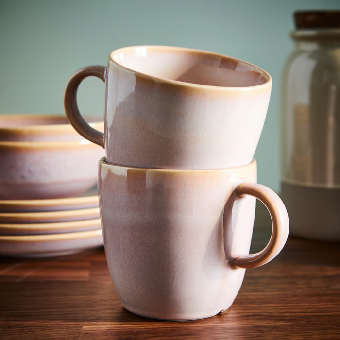 IKEA FÄRGKLAR Mug, light pink, 42 cl, stacked with another mug in a similar earthy tone on a wooden surface. The glossy ceramic finish enhances its elegant design, while the soft gradient of light brown and beige adds a warm, cozy aesthetic.-90604883