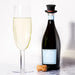 Champagne bottle with black top hat silicone stopper and filled flute – playful leak-proof seal with red band accent – 1600002389866 13964736