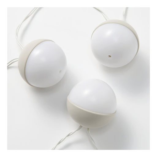 Three white spherical lamps on a light gray background