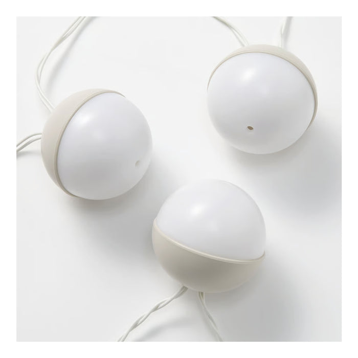 Three white spherical lamps on a light gray background