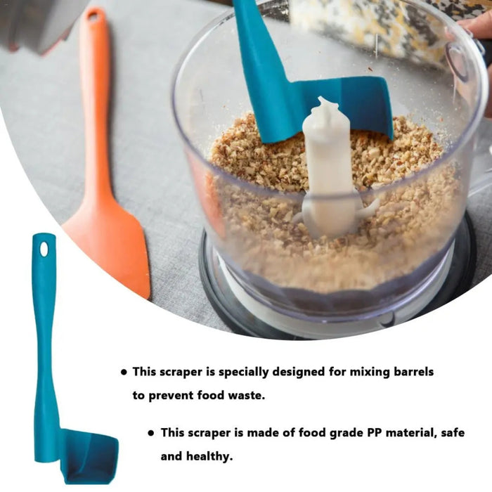 Teal L-shaped rotary scraper tool used inside food processor with chopped nuts – designed to reduce food waste and scrape around blade column – 777701 13962262