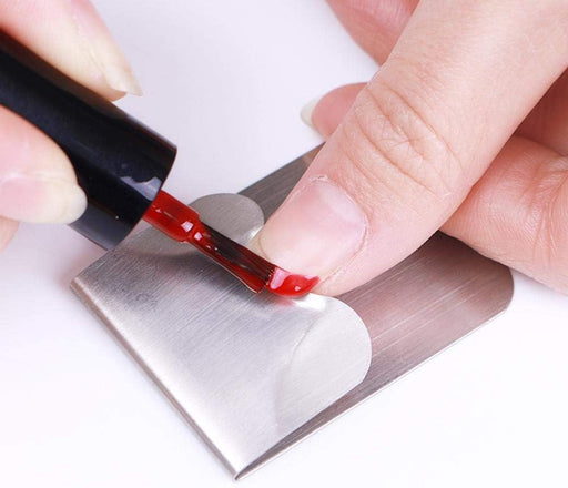 Red liquid being applied to a metal surface with a brush
