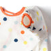 Baby outfit with colorful polka dot pattern and orange accents on a white background