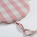 Pink and gray checkered fabric with a strap on a white background