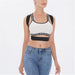Woman wearing a white sports bra with black straps and text, paired with blue jeans on a white background.