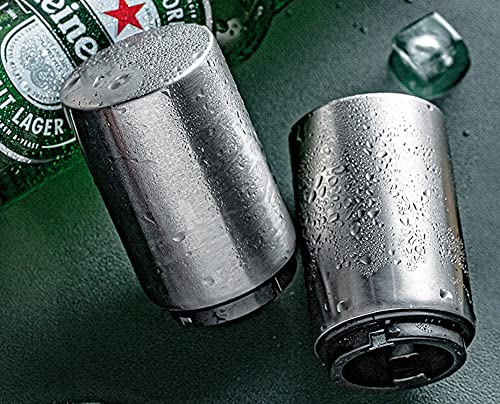 Two metal can coolers with water droplets on a green surface, with a beer bottle in the background.