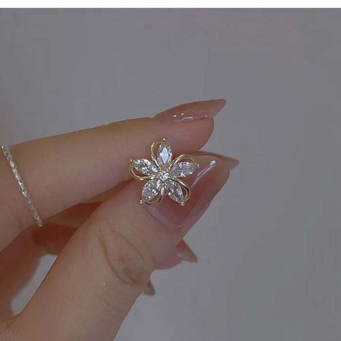 Digital Shoppy High-grade Ear Studs, close-up of hand holding five-petal zircon earrings with manicured nails