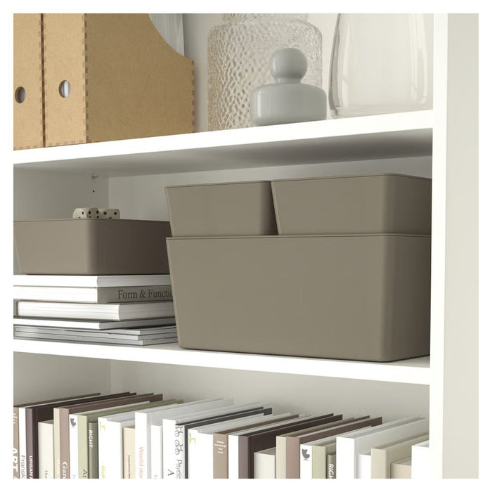 Shelving unit with beige storage boxes, books, and decorative items.