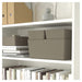 Shelving unit with beige storage boxes, books, and decorative items.