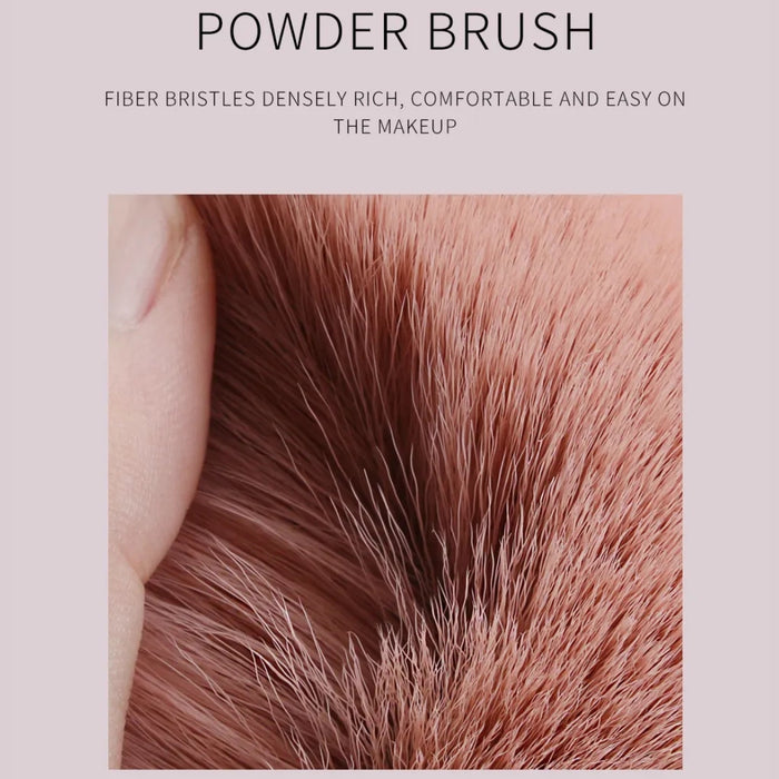 Close-up of fingers pressing into dense pink bristles of powder brush with descriptive text