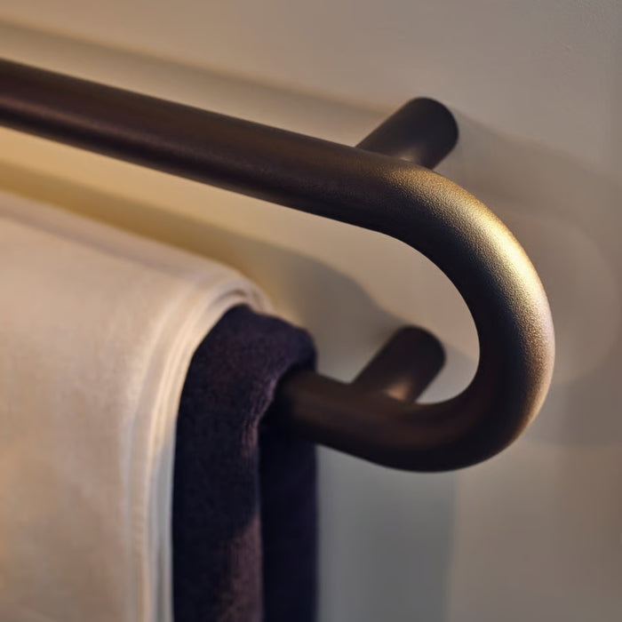 Metal towel rack with a purple towel on a neutral background