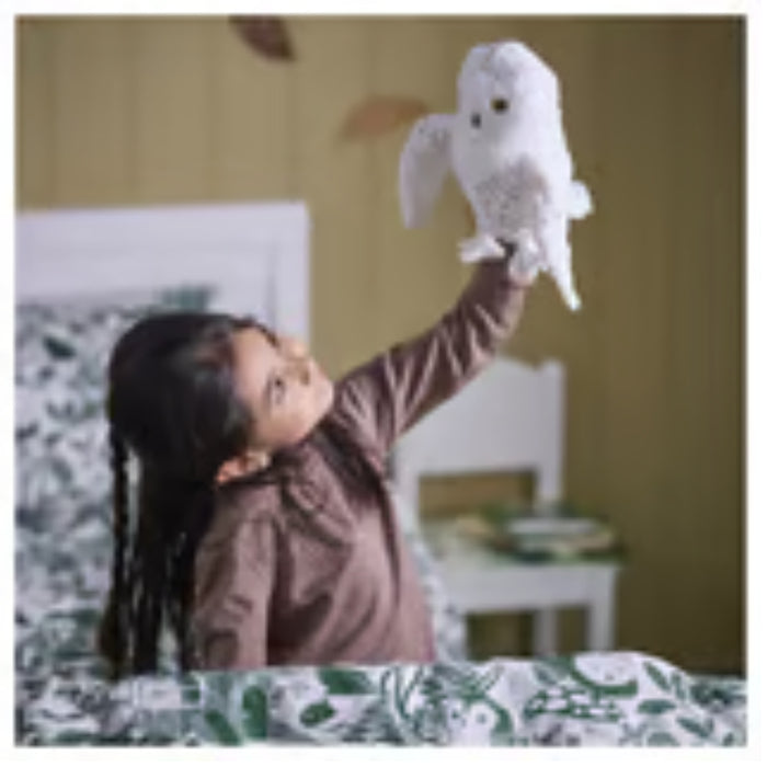 IKEA SKOGSDUVA soft toy – child holding snowy owl puppet in cozy bedroom with forest-themed bedding and wooden wall - 50576896