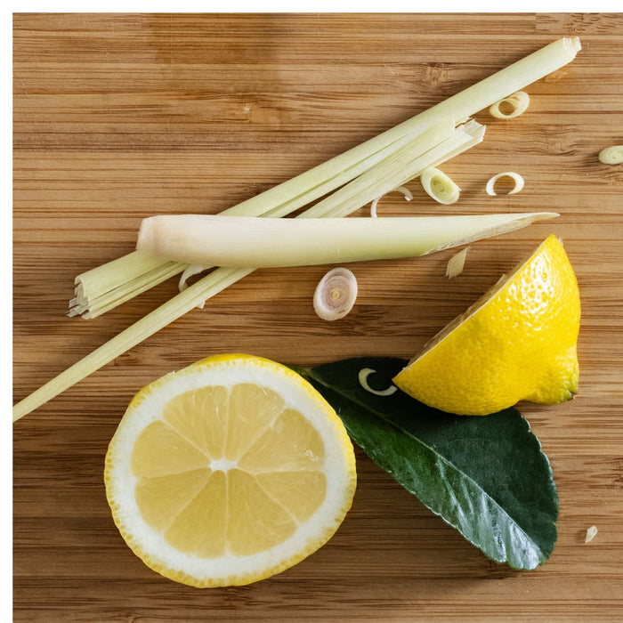 IKEA BLODHÄGG scented tealight – lemon & lemongrass/yellow, fresh lemongrass, lemon halves, and kaffir lime leaves on cutting board - 30571507