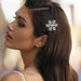 Crystal snowflake hair clip – worn above ear on dark brown hair with white top in natural light