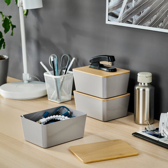 Minimalist desk setup featuring a white desk lamp, mesh pen holder with stationery, two stacked storage boxes with wooden lids, stainless steel water bottle, and clipboard with papers—ideal for organized workspaces and home office inspiration.-20599149