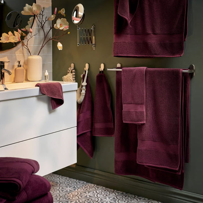 IKEA FREDRIKSJÖN washcloth in deep red, 30x30 cm (12x12"); styled in coordinated bathroom with matching bath and hand towels – shown hanging near white sink, round mirror, and floral vase for elegant, burgundy-themed decor - 70552762