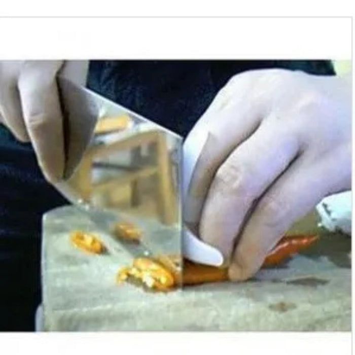 Close-up of hands wearing gloves working with gold jewelry on a stone surface.