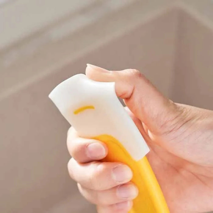 Close-up of hand holding sponge-style cleaning tool with yellow handle and white scrubber – 1598449174494 14075321