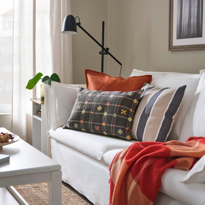 White sofa with colorful pillows and a red blanket in a living room setting.