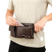 Person placing a smartphone into a brown leather waist pouch with multiple compartments – 1600007588949 14145394