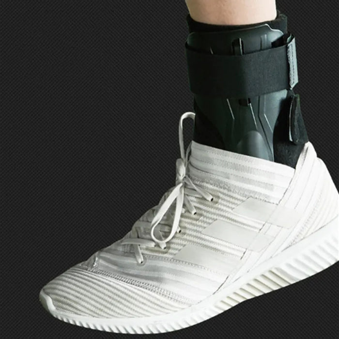 White athletic shoe with a black ankle support brace on a dark background