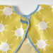 Close-up of IKEA KLADDIG bib in yellow/white; features cheerful white sun pattern on yellow fabric with blue trim and fastening loop – ideal for toddlers’ mealtime or craft protection - 00607145