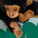 Close-up of SANDLÖPARE chimpanzee plush showing stitched details, shiny eyes, and fabric patches on hand and foot