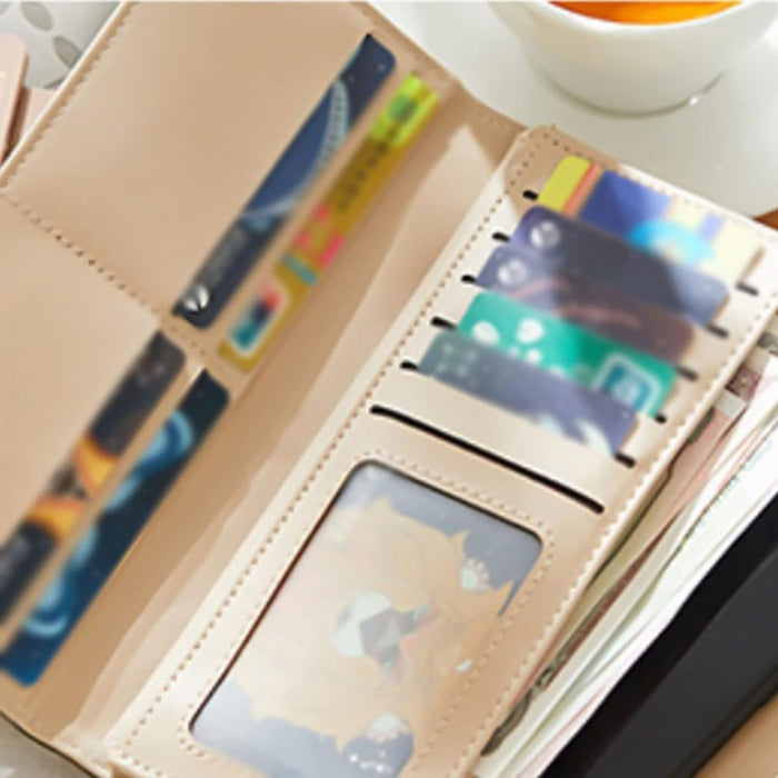 Green women’s wallet – open purse with cards, fox-themed ID, and banknotes beside orange drink