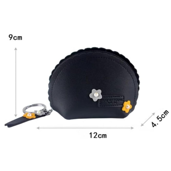 Digital Shoppy coin key case – black pouch with tassel, bead, and yellow flower charm placed on white surface