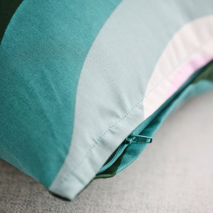 Close-up of IKEA MYGGBLOMSTER cushion cover with teal, light blue, and pink wavy stripes; visible teal zipper detail on smooth fabric – 50582133