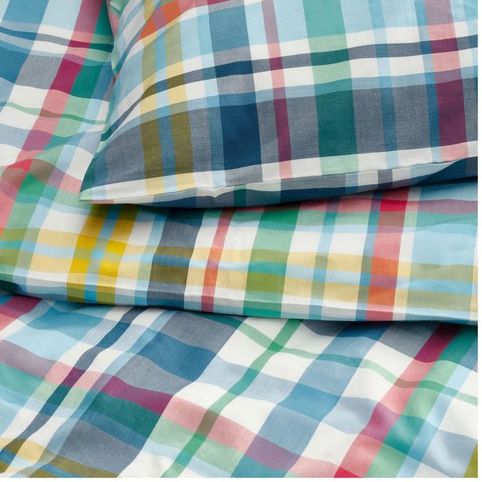 Colorful plaid patterned fabric with a pillow on top