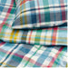 Colorful plaid patterned fabric with a pillow on top