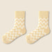 Pair of mango yellow fleece-lined socks with white zigzag pattern laid flat