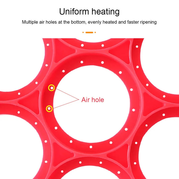 Red 7-hole silicone pancake and egg mold shown from the underside, with multiple small circular air holes around its base. Text on the image reads: “Uniform heating” and “Multiple air holes at the bottom, evenly heated and faster ripening.” This close-up highlights the mold’s thoughtful airflow design for consistent cooking and quicker results -2147192 13025440.