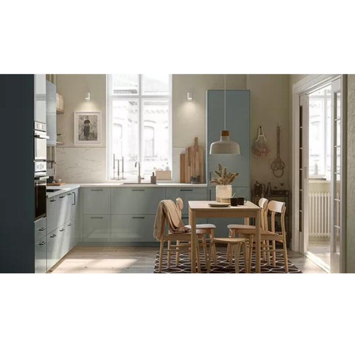 Modern kitchen with dining area featuring a table and chairs.