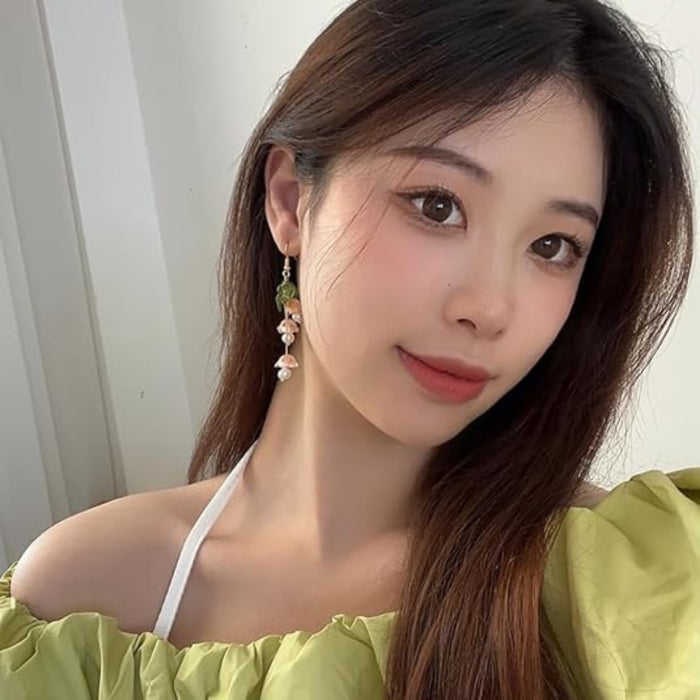 Digital Shoppy Lily of the Valley earrings – close-up of whimsical floral earrings with pink mushrooms and pearl beads held in hand