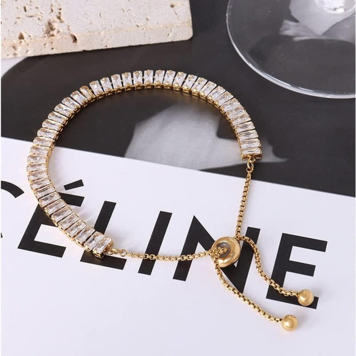 Gold rhinestone bracelet – displayed on fashion surface with printed material and glass decor