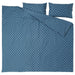 IKEA ÄNGSNEJLIKA duvet cover partially folded back to reveal reversible design: one side with large circular blue motifs, the reverse with smaller, densely packed geometric shapes in similar tones.