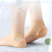 Beige compression socks being worn on a light background