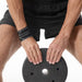 Athlete using the breathable wrist support while handling a heavy gym weight plate for joint protection.