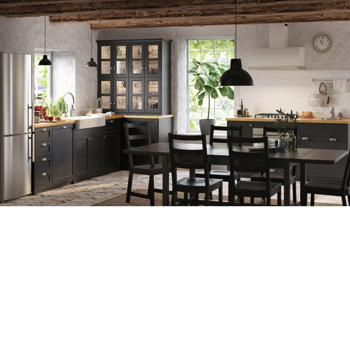 Modern kitchen with black cabinets, wooden dining table, and chairs.