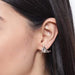 Triangle gold earrings – close-up of triangular crystal earrings with planetary-style gold ring, worn on ear

