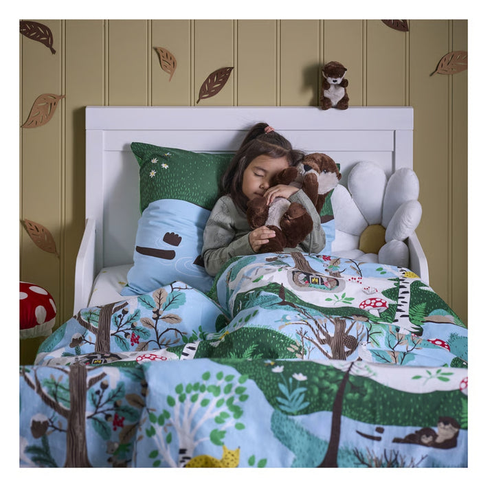 IKEA SKOGSDUVA soft toy – child sleeping with otter plush toy, surrounded by forest-themed bedding and mushroom cushion - 90576899