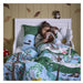 IKEA SKOGSDUVA soft toy – child sleeping with otter plush toy, surrounded by forest-themed bedding and mushroom cushion - 90576899