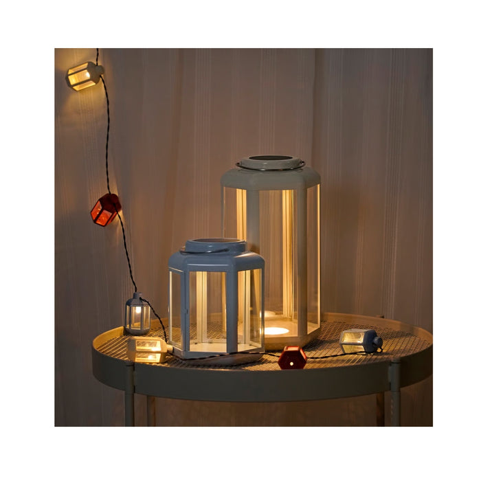 Decorative lanterns on a table with warm lighting against a neutral background