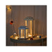 Decorative lanterns on a table with warm lighting against a neutral background