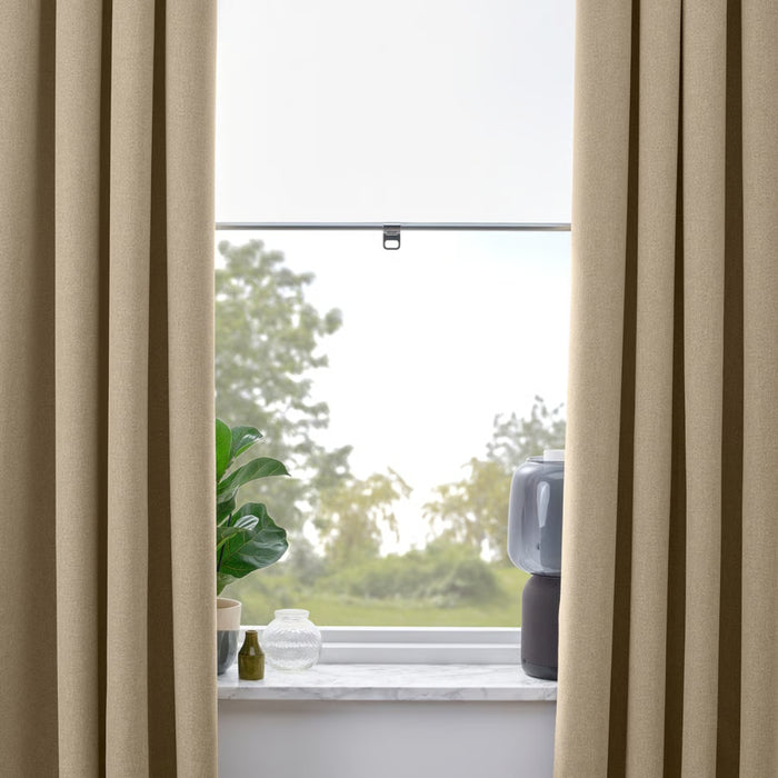 Beige curtains with a window in the background showing greenery