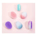 Solid pastel color hair comb styled beside mirror and makeup items