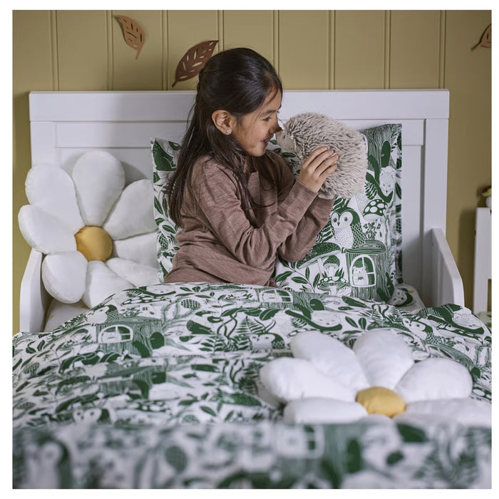 IKEA SKOGSDUVA soft toy – child smiling on bed with hedgehog plush, surrounded by forest-themed decor and flower cushions - 70576904