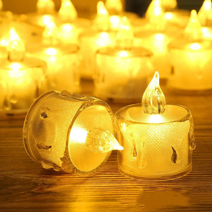 Two glowing tealight candles in decorative holders on a wooden surface.